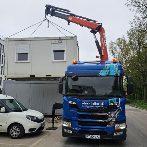 LKW mit ATLAS Ladekran beim verladen eines Aufenthaltscontainers
